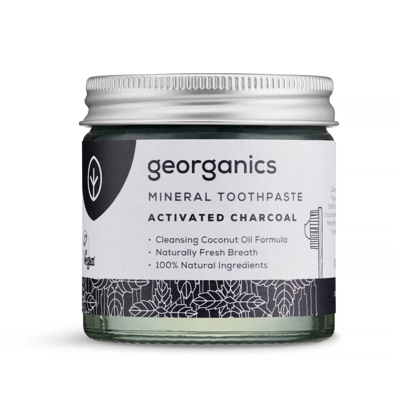 Georganics Aktiivihiili Hammastahna -lasipurkki; pyöreä ja läpinäkyvä purkki mattapintaisella hopeanvärisellä kannella, sisällä tummaa tahnaa; etiketissä lihavoitua ja tavallista tekstausvapaata tekstiä, kuten "naturally fresh breath" ja "100% natural ingredients", sekä mainintoja aktiivihiilestä ja kookosöljystä; kuvattu valkoista taustaa vasten pehmeässä valaistuksessa, ei ihmisiä näkyvissä.