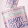 Heey! Beauty Collagen; lähikuva vaaleanpunaisesta muovipurkista tekstillä Beauty Collagen, täynnä valkoisia kapseleita; etiketissä selkeää groteskitekstiä, joka kertoo tuotteen olevan vegaaninen kollageenitehostaja biotiinilla hiuksille, kynsille ja iholle; purkin pinta mattapintainen ja pyöreähkö muotoinen; taustalla epätarkkana toinen samanlainen vaaleanpunainen purkki.