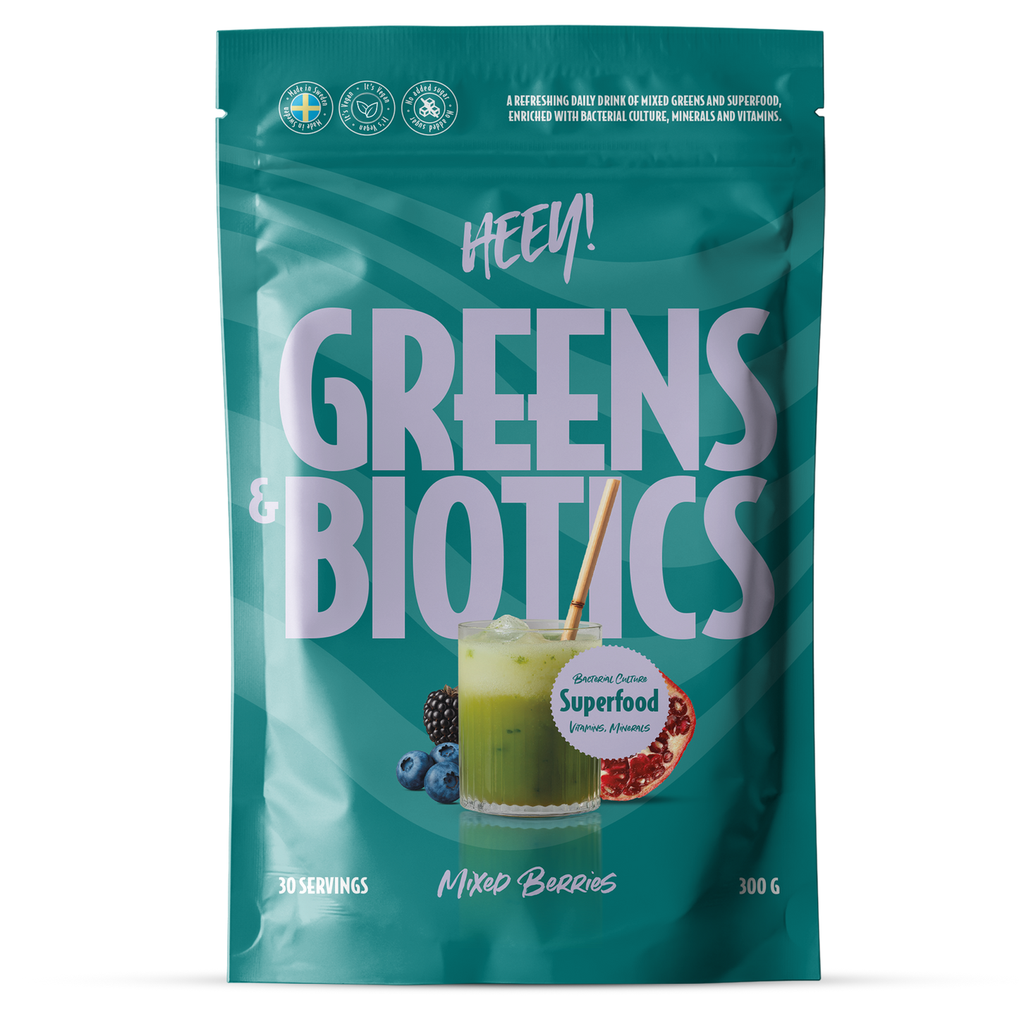 Heey! Greens & Biotics Superfood Mixed Berries: turkoosi mattapintainen pussi pystyasennossa, lihavoitu valkoinen ja marjansävyinen groteskikirjasin; etiketissä kuva lasista vihreää mehua bambupillillä sekä sekoitettuja marjoja; teksti sisältää "HEY! GREENS & BIOTICS Mixed Berries", 30 annosta, 300 g, superfood-ainesosia ja suolistoterveyshyötyjä; neutraali tausta, lähikuva tuotteesta.