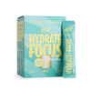 Heey! Hydrate & Focus Electrolytes, maku Lemon; pakkaus ja yksittäinen tikkupussi Hey! Hydrate & Focus -elektrolyyttijauhetta sitruunan maulla; pakkaus turkoosi mattapinnalla, lihavoitua keltaista tekstiä ja kuva lasista sitruunaviipaleineen laatikon kannessa; molemmissa painettu tuotenimi ja maku; vaalea tausta, ei ihmisiä tai käsiä kuvassa.