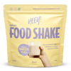 Heey! Vegan Food Shake, maku Vanilla; keltainen mattapintainen pussi tekstillä Heey! Food Shake pystyssä tasaisella alustalla; lihavoitua valkoista ja mustaa groteskitypografiaa, etiketissä complete meals, 25 vitamins & minerals ja 33g protein; ihmiskäsi pitelee kirkasta lasillista vaaleaa vanilja-shaketta pussin vieressä; tausta ei näytä yksityiskohtia.