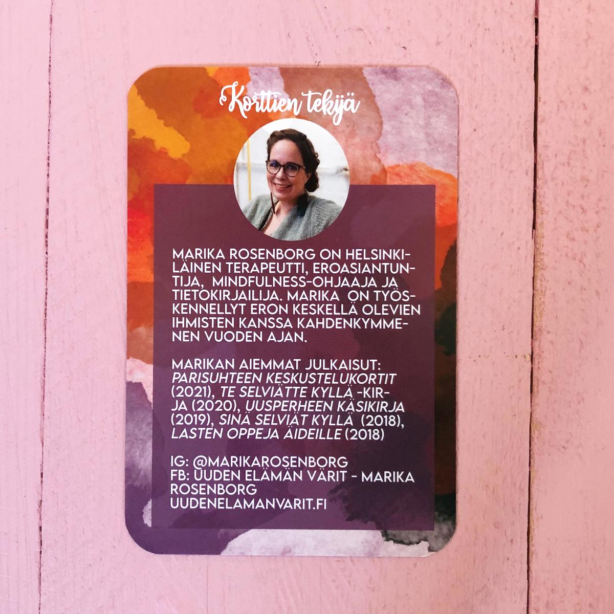 Hidasta Elämää Erohehku-kortit; kortti, jossa valokuva naisesta ja suomenkielinen teksti esittelee Marika Rosenborgin, terapeutin ja kirjailijan, kertoen hänen pätevyydestään, valikoiduista julkaisuistaan ja yhteystiedoista; suorakulmainen kortti matalla pinnalla vaaleanpunaisella ja oranssilla vesiväritaustalla; pääteksti puhdasta groteskia mustalla; ei pakkausta näkyvissä, tausta neutraali ilman lisäesineitä tai käsiä.