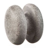Two smooth, round gray stones are balanced upright and pressed together, creating a narrow gap between them against a white background. The stones have a matte finish and no visible markings or labels. No packaging is present. The image uses even lighting with no shadows, showing only the stones without people or additional objects in frame.