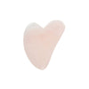 A smooth, rose quartz heart-shaped stone tool is positioned on a plain white background. The tool is light pink, semi-translucent, with a polished glossy surface and no visible markings or labels. There is no packaging, text, or human presence shown in the image.