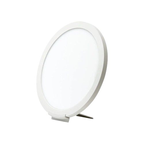 A round, white LED therapy lamp with a thin frame, shown propped up on a small stand against a plain white background. Surface is matte with no visible texture or gloss. No visible packaging. No text or branding on the product itself. Background is evenly lit with no shadows or props, and there are no people present in the image.