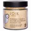 JOIK Organic Warming Magnesium Jalkakylpysuola; lasipurkki, merkitty JOIK Organic Warming Ginger & Mustard Magnesium Footbath Salt, mustalla kannella, sisältää vaaleankeltaista magnesiumpitoista kylpysuolaa; purkki on läpinäkyvä ja sylinterinmuotoinen kiiltävällä mustalla kierrekorkilla; etiketti on valkoinen vähäisellä mustalla groteskitekstillä; ei ihmisiä, käsiä tai rekvisiittaa näkyvissä; tuote on ainoa esine kuvassa yksivärista taustaa vasten keskitetysti kuvattuna.