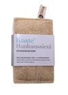 Kaste Hankaussieni, suorakaiteen muotoinen luonnollinen puhdistussieni etiketillä "Kaste Hankaussieni" ja suomenkielistä tekstiä, yläosassa pieni kangaslenkki; pinta karkea ja kuituinen, väriltään ruskehtavan vaalea ja mattapintainen; etiketin typografia yksinkertainen ja groteskinen; ei muuta pakkausta kuin kiinnitetty etiketti; tuote kuvattuna yksinkertaista taustaa vasten, ei ihmisiä eikä käsiä näkyvissä.