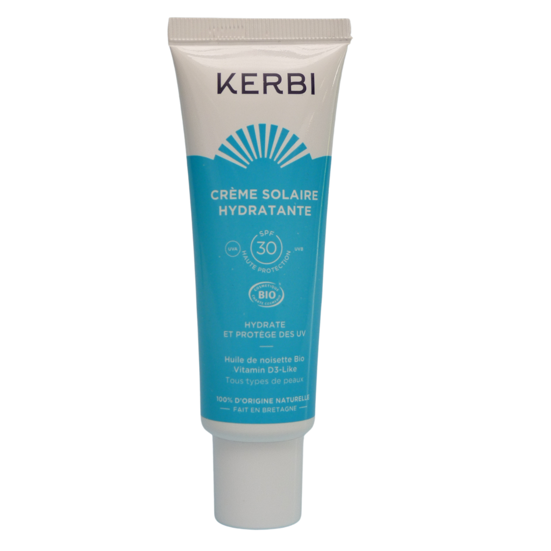 Kerbi Kosteuttava Kasvovoide SPF 30; valkoinen ja sininen tuubi seisoo pystyssä mattapinnalla; tuotteessa teksti ”KERBI Crème Solaire Hydratante SPF 30”, lisäksi mainittu kosteuttava aurinkosuoja, luonnonmukaiset ainesosat ja sopivuus kaikille ihotyypeille; typografia lihavoitua brändinimelle ja tuoteotsikolle; tausta yksivärinen valkoinen, ei ihmisiä tai rekvisiittaa kuvassa.
