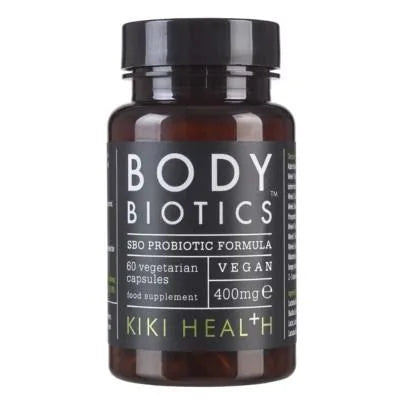 Kiki Health Body Biotics Maitohappobakteeri; pullo KIKI Health Body Biotics SBO Probiotic Formula -tuotetta, sisältää 60 kasvis- ja vegaanikapselia (400 mg kutakin), merkitty korkealaatuiseksi elintarvikelisäksi; sylinterinmuotoinen tummanruskea lasipullo mustalla kierrekorkilla, mattapintainen paperietiketti mustana valkoisin ja vihrein groteskitekstein; tuotenimi kaikki suuraakkosin; valkoinen tausta, studiokuva, ei ihmisiä tai käsiä näkyvissä.