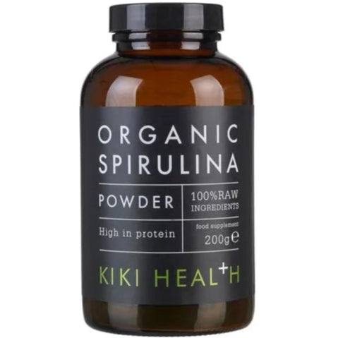 Kiki Health Luomu Spirulina-jauhe; ruskea sylinterinmuotoinen pullo mustalla kierrekorkilla, mattapintainen viimeistely ja suorakulmainen etiketti etupuolella; etiketissä valkoista ja vihreää groteskitekstiä mustaa taustaa vasten; luettavassa tekstissä lukee ruskea pullo, merkitty Organic Spirulina Powder, 100-prosenttisesti raakoja ainesosia, runsaasti proteiinia ja antioksidantteja, 200 g, KIKI Health; valkoinen tausta, studiotuotekuva, ei ihmisiä tai käsiä näkyvissä.