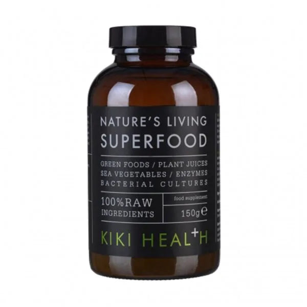 Kiki Health Natures Living Luomu Superfood-jauhe; ruskea pullo, merkitty Natures Living Superfood by Kiki Health, sisältää 150 g jauhemaista lisäravinnetta vihreistä kasveista, kasvimehuista, merikasveista, entsyymeistä ja hyödyllisistä bakteerikannoista; pullo on sylinterinmuotoinen kiiltäväpinnalla mustalla kierrekorkilla; etiketissä groteskitekstiä valkoisena ja vihreänä mattamustalla pohjalla; tuote kuvattu valkoista taustaa vasten, ei ihmisiä tai käsiä näkyvissä.