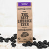 Klepper & Klepper Gluteeniton Lakritsi Coffee; ruskea paperipussi tekstillä ”The Best Licorice Ever by Klepper & Klepper” valkoisella alustalla; pussi mattapintainen ja pystyssä, painettua mustaa tekstiä sekaisin antiikva- ja groteskifonteilla; pussin ympärillä kiiltäviä mustia lakritsipaloja kahvipavun muodossa; ei ihmisiä tai käsiä näkyvissä; kuva otettu hieman viistosti ylhäältä.