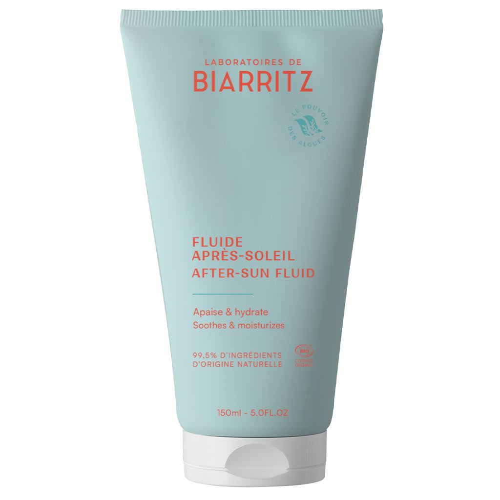 Laboratoires de Biarritz After-Sun Fluid: vaaleansininen tuubi tekstillä "Laboratoires de Biarritz After-Sun Fluid" oranssilla ja valkoisella tekstillä, kosteuttavia ja rauhoittavia ominaisuuksia; tuubi on 150 ml, muovia, mattapinnalla ja valkoisella läppäkorkilla; etuosan teksti korostaa 99,5 % luonnollisia ainesosia; tuote seisoo pystyssä valkoista taustaa vasten studiokuvassa.