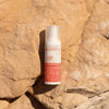 Laboratoires de Biarritz Baby & Child Sun Cream Aurinkovoide lapsille SPF50+; pullo Biarritz SPF 50+ -aurinkovoidetta lepää auringon lämmittämällä, tekstuurisella kivipinnalla ulkona, korostaen laadukasta aurinkosuojaa; pullo valkoinen mattapinnalla ja oranssilla korkilla, sylinterin muotoinen; pakkauksessa lihavoitua groteskitekstiä ”Biarritz” ja ”SPF 50+” selkeästi näkyvissä; ei ihmisiä tai käsiä; luonnollinen ulkovalo valaisee kohtauksen lähikuvassa.