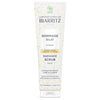 Laboratoires de Biarritz Cleansing Care Kasvokuorinta; valkoinen tuubi Radiance Scrub -kasvokuorinnalle kultaisin yksityiskohdin ja ranskan-englanninkielisin tekstein; suunniteltu hellävaraiseen kuorintaan luonnollisin ainesosin, sopii kaikille ihotyypeille; mattapintainen lieriön muotoinen tuubi, vaalea tausta, ei ihmisiä tai käsiä.