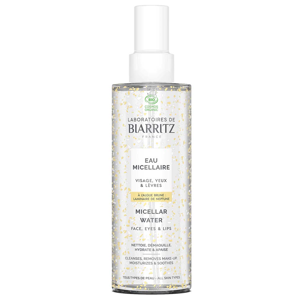 Laboratoires de Biarritz Cleansing Care Misellivesi; pullo Eau Micellaire -misellivedelle valkoisella ja kultaisella etiketillä; kirkas lieriön muotoinen muovipullo kiiltäväpintaisena; etiketissä modernia groteskityyppografiaa, valkoinen pohja ja metallinkultaiset korostukset sekä vähäistä grafiikkaa; pullon korkki valkoista muovia, litteä yläosa; vaalea tausta, ei ihmisiä tai toimintaa.