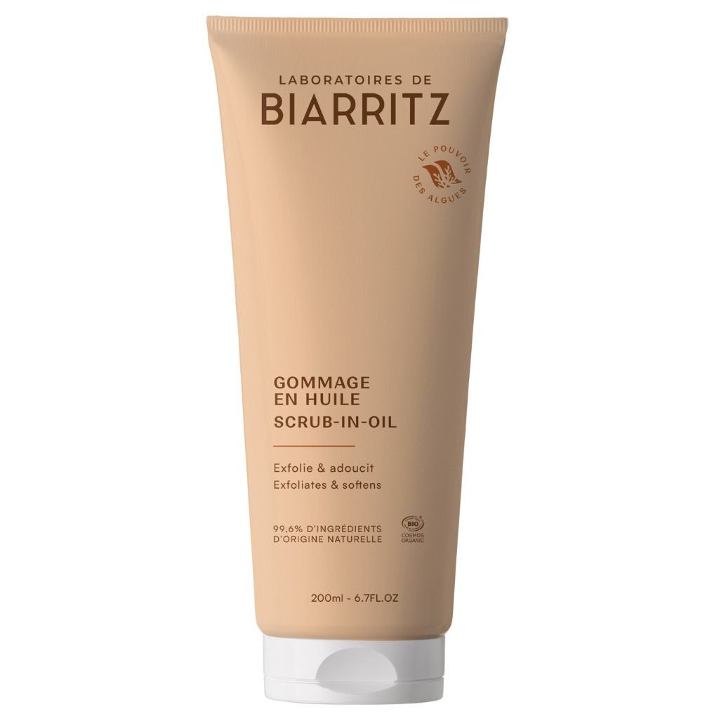Laboratoires de Biarritz Oil-In Body Scrub Vartalokuorinta; beige tuubi Laboratoires de Biarritz Gommage en Huile (Scrub-in-Oil) -vartalokuorintaa mustalla tekstillä seisoo pystyssä; pinta matta ja tuubi pehmeää muovia pyöristetyllä korkilla; etiketissä ”200 ml (6,7 fl oz)” ja maininta kuorivista ja pehmentävistä ominaisuuksista; groteskikirjasin etupuolella; tasainen neutraali tausta, pelkkä tuotekuva, ei ihmisiä tai käsiä.