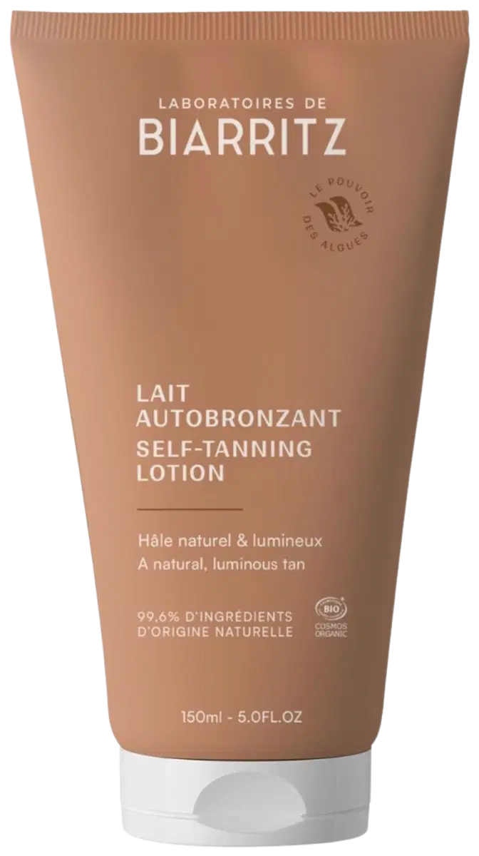 Laboratoires de Biarritz Self-Tanning Lotion Itseruskettava Voide: tuubi Laboratoires de Biarritz -itseruskettavaa voidetta, 150 ml, merkitty luonnollisilla ainesosilla kirkkaan, hehkuvan rusketuksen aikaansaamiseksi; pakkauksessa valkoista ja kultaista tekstiä; tuubi seisoo pystyssä mattapinnalla sylinterimäisenä; groteskikirjasin; ei ihmisiä tai käsiä näkyvissä; valkoinen studiotausta, lähikuva tuotteesta.