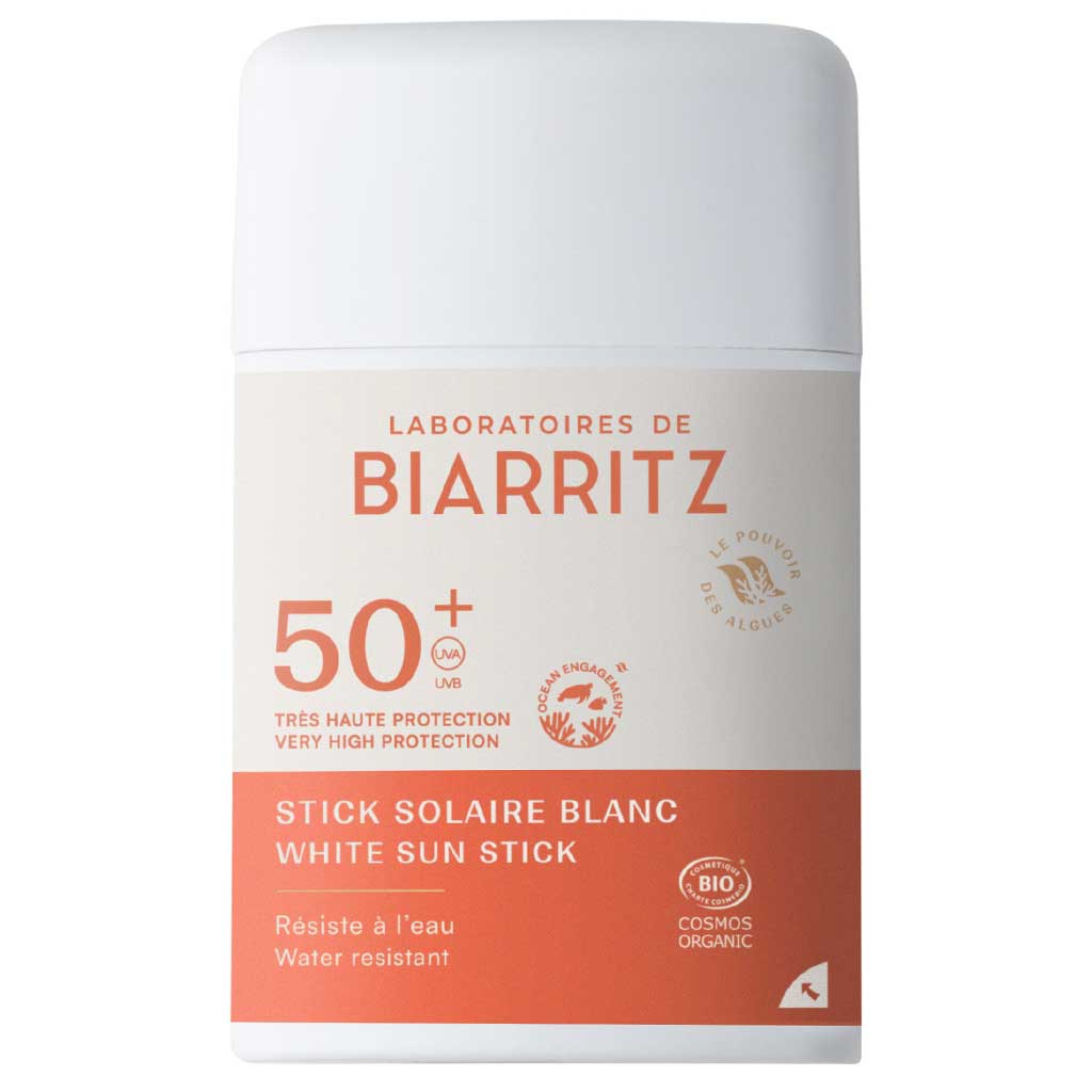 Laboratoires de Biarritz Stick Solaire Aurinkovoidepuikko Valkoinen SPF50+; valkoinen ja persikanvärinen puikko Laboratoires de Biarritz White Sun Stick SPF 50+ -tuotetta, merkitty vedenkestäväksi, erittäin korkean suojan omaavaksi, luomuksi, riutansuojelevaksi ja kaikille ihotyypeille sopivaksi; sylinterin muotoinen muovituubi mattapinnalla; luettavaa brändi- ja tuotetietoa groteskikirjasimella etuetiketissä; kuvassa vain tuote vaaleaa taustaa vasten, ei ihmisiä tai rekvisiittaa.