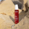 Laboratoires de Biarritz Suncare Invisible Oil SPF50; pullo Biarritz Invisible Sun Oil SPF 50 -öljyä seisoo pystyssä beigellä kivellä auringonvalon valaisemana ja epätarkkaa kivistä taustaa vasten; pullo sylinterin muotoinen puoliläpinäkyvää tai huurteista muovia kiiltopinnalla, oranssi pumppukorkki; valkoinen groteskikirjasin näyttää brändi- ja tuotenimen etuetiketissä; ei ihmisiä tai näkyvää toimintaa kuvassa.