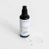Laponie of Scandinavia Gentle Exfoliating Essence; musta muovinen pumppupullo kiiltopinnalla seisoo pystyssä yhtenäisellä valkoisella taustalla kahden pienen kirkkaan geelipisaran vierellä; etiketissä lukee ”Laponie of Scandinavia Gentle Exfoliating Essence” yksinkertaisella groteskikirjasimella; ei ihmisiä tai käsiä kuvassa; tuote korostaa hellävaraisia kuorintaominaisuuksiaan.