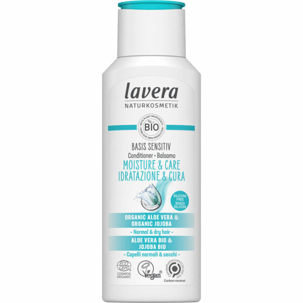 Lavera Basis Sensitiv Moisture & Care Hoitoaine -pullo normaalille ja kuivalle hiukselle, valkoinen mattapintainen pullo pyöristetyin reunoin; etusivun etiketissä teksti luomualoevera- ja jojobaöljystä, vegaanisuudesta, luomustatuksesta ja hiilineutraaliudesta sinisellä ja mustalla groteskikirjasimella; ei ihmisiä tai käsiä näkyvissä; tausta neutraali yksinkertaisella valaistuksella.