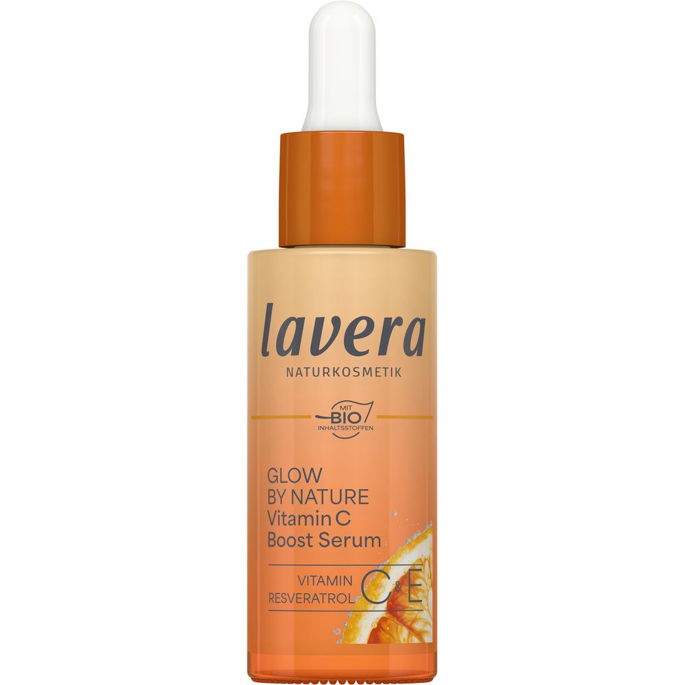 Lavera Glow By Nature Vitamin C Boost Serum; tippapullo Lavera Glow by Nature Vitamin C Boost Serum -seerumia, eloisan oranssi-keltainen liukuväritetty etiketti, valkoinen teksti ja appelsiiniviipalekuvitus alaosassa raikkaan tehostuksen merkiksi; pullo sylinterin muotoinen kiiltopinnalla ja valkoisella tippakorkilla; groteskikirjasin käytössä; tuote vaaleaa taustaa vasten studiokuvassa, ei ihmisiä tai käsiä.