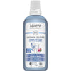 Lavera Complete Care Mouthwash -pullo luomuminttua ja raunioyrttiä sisältävällä suuvedellä; lieriömäinen kirkas muovipullo, jonka läpi näkyy sininen neste, sekä valkoinen kierrekorkki; valkoisessa etiketissä sinisiä yksityiskohtia, groteskitekstiä ja pieniä pyöreitä kuvakkeita vegaanisuudesta ja eläinkokeettomuudesta; pääteksti keskitetty; tausta valkoinen, ei ihmisiä tai rekvisiittaa; tuote kuvattu suoraan edestä.
