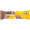 Leader Performance Protein Crisp Hazelnut Fudge; Leader Protein Crisp Hazelnut Fudge -patukka ruskeassa ja keltaisessa mattapintaisessa pakkauksessa, suorakaiteen muotoinen kierretyin ja saumatuin päin; valkoista, lihavoitua tikkukirjasinta näyttää tekstit ”20g protein”, ”no added sugar”, paino 55 g; olympiarenkaiden kuvitus oikealla puolella; kuvassa vain pakattu patukka tasaisella taustalla, ei ihmisiä tai rekvisiittaa.