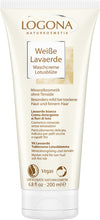 Tube of LOGONA Weiße Lavaerde Waschcreme Lotusblüte. The tube is white with muted pink and grey graphics, matte finish, and rounded edges. The front label contains clear typography in a mix of uppercase and lowercase. Product volume is indicated as 200 ml. No people or hands visible; shot has a plain background with even lighting. Text highlights it as a mineral-based, vegan cleansing cream with gentle lotus blossom for dry skin and fine hair, free of sulfates, with multilingual product details and a 200ml