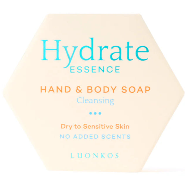 Luonkos Hydrate Essence Hand & Body Soap; kuusikulmainen saippuapakkaus tekstillä ”Hydrate Essence Hand & Body Soap, Cleansing, Dry to Sensitive Skin, No Added Scents, LUONKOS”, kosteuttavaa sinistä ja oranssia tekstiä kermanvärisellä taustalla; rasia mattapintainen ja terävärajainen; typografia selkeää tikkukirjasinta; kuva näyttää tuotteen tasaisella valkoisella tai vaalealla taustalla ilman ihmisiä tai rekvisiittaa.