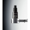 Madara AGE PRO Contour Wrinkle Eye Cream; musta pullo MÁDARA Age Pro Contour Wrinkle Eye Cream -tuotetta on kiinnitetty metalliseen pidikkeeseen liukuväritaustaa vasten, joka häivytetään tummanharmaasta vasemmalta valkoiseen oikealla, korostaen tuotteen tyylikästä muotoilua; pullo on mattapintainen ja sylinterinmuotoinen, etuetiketissä valkoista groteskitekstiä tuotenimestä; ei ihmisiä tai käsiä näkyvissä; studiokuva.