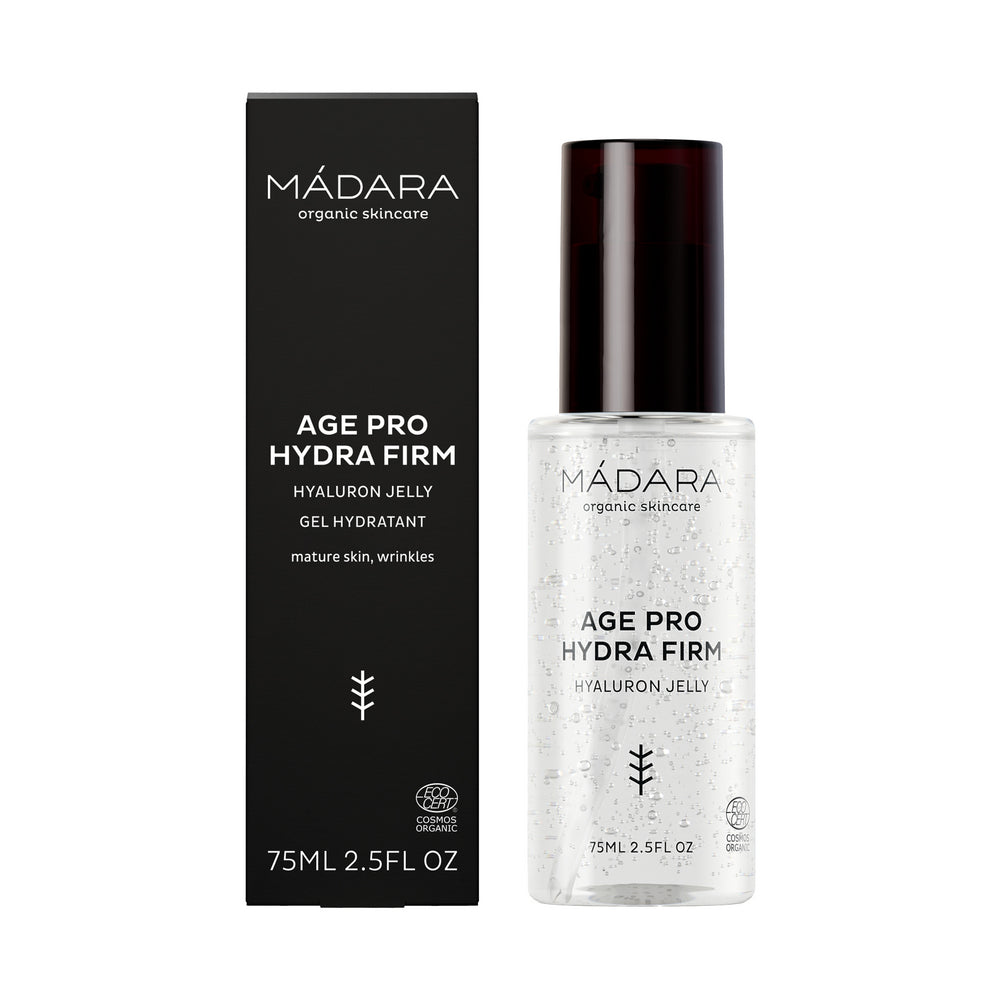 Madara AGE PRO Hydra Firm Hyaluron Jelly; pullo MÁDARA Age Pro Hydra Firm Hyaluron Jelly -tuotetta ja sen musta laatikkopakkaus, molemmat merkitty kypsälle iholle ja ryppyjen hoitoon, sisältävät edistynyttä hyaluronia syvään kosteutukseen, 75 ml (2,5 fl oz); pullo on sylinterinmuotoinen pumppuannostelijalla ja mattapinnalla; pakkausteksti on valkoista groteskifonttia; molemmat esineet seisovat vierekkäin valkoista taustaa vasten; ei ihmisiä tai käsiä näkyvissä.
