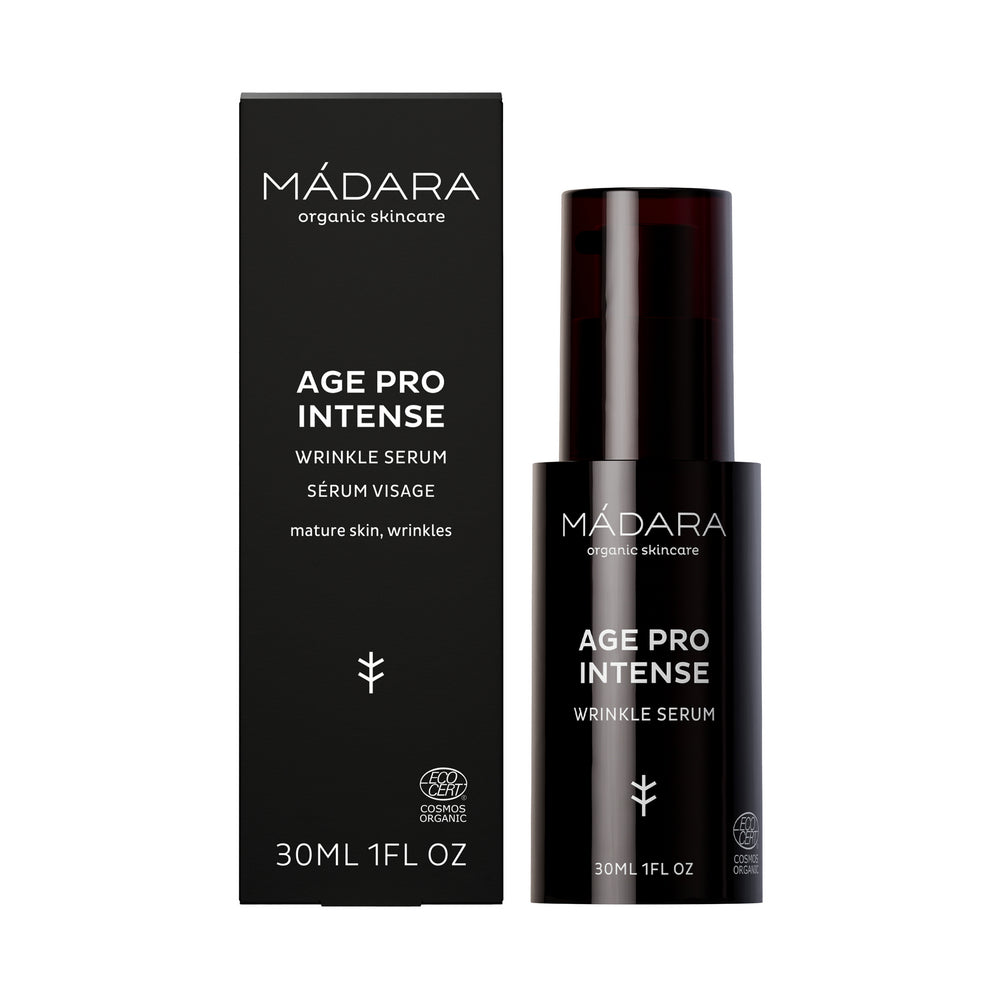 Madara AGE PRO Intense Wrinkle Serum; musta pullo ja yhteensopiva laatikko MÁDARA Age Pro Intense Wrinkle Serum -tuotetta kypsälle iholle, koko 30 ml, valkoista tekstiä ja pelkistettyä merkintää; molemmat mattapintaisia; pullo on sylinterinmuotoinen pumppuannostelijalla; etiketin typografia groteskia suuraakkosin; tausta yksivärinen ja koristelematon; ei ihmisiä tai käsiä näkyvissä; edistynyt seerumi kohdistuu ikääntymisen näkyviin merkkeihin tasoittaakseen ja elvyttääkseen ihoa.