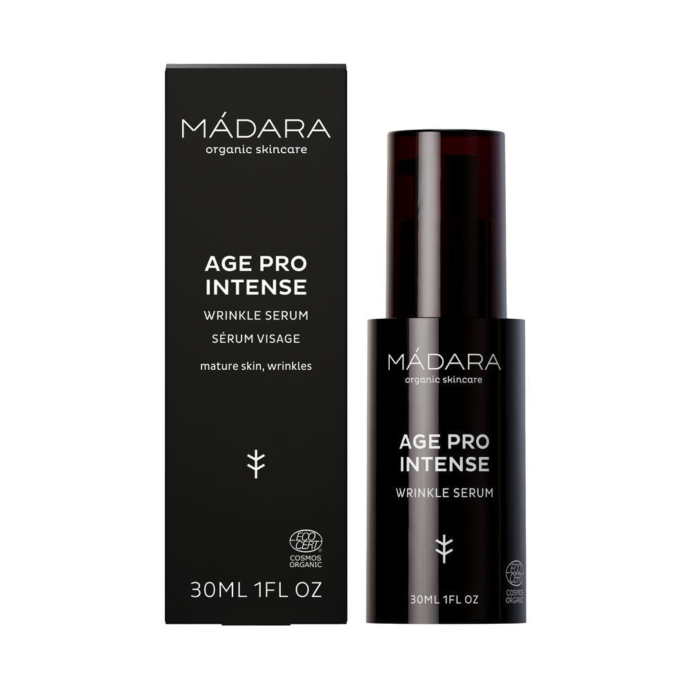Madara AGE PRO Intense Wrinkle Serum; musta pullo ja yhteensopiva laatikko MÁDARA Age Pro Intense Wrinkle Serum -tuotetta kypsälle iholle, koko 30 ml, valkoista tekstiä ja pelkistettyä merkintää; molemmat mattapintaisia; pullo on sylinterinmuotoinen pumppuannostelijalla; etiketin typografia groteskia suuraakkosin; tausta yksivärinen ja koristelematon; ei ihmisiä tai käsiä näkyvissä; edistynyt seerumi kohdistuu ikääntymisen näkyviin merkkeihin tasoittaakseen ja elvyttääkseen ihoa.