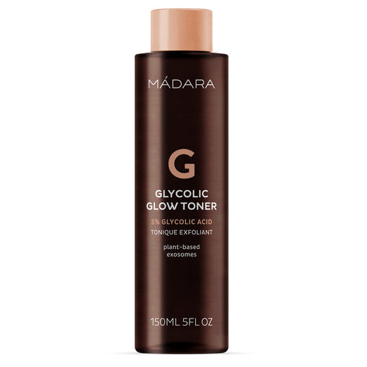 Madara Glycolic Glow Toner; ruskea pullo MÁDARA Glycolic Glow Toner -kasvovettä beigellä korkilla, valkoinen teksti kertoo 5 % glykolihaposta, kasviperäisistä eksosomeista ja 150 millilitran (5 fl oz) tilavuudesta; pullo sylinterin muotoinen kiiltopinnalla; etikettiteksti nykyaikaisella groteskikirjasimella; ei rekvisiittaa tai ihmisiä, tausta tasainen ja neutraali, tuote keskitettynä kuvaan.
