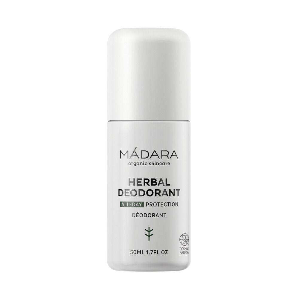 Madara Herbal Deodorant; valkoinen roll-on-pullo, jossa teksti ”MÁDARA organic skincare HERBAL DEODORANT ALL-DAY PROTECTION”, vihreä lehtikuvake ja sertifiointilogoja; pakkaus lieriömäinen pyöristetyllä korkilla, mattapinta ja musta groteskiteksti; pakkauskoko merkitty 50 ml (1,7 fl oz); ei ihmisiä tai käsiä, tasainen tausta.