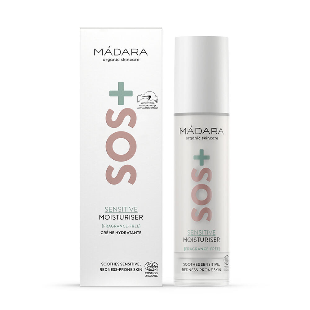 Madara SOS+ SENSITIVE Moisturiser; MÁDARA SOS Sensitive Moisturiser -pullo seisoo valkoisen pakkauslaatikkonsa vieressä, korostettuna pinkillä SOS-tekstillä, vihreällä rististä ja merkin logolla; sekä pullo että laatikko ovat mattapintaisia, pullo on sylinterinmuotoinen pumppuannostelijalla; typografiassa groteskityylejä mustalla ja pinkillä; ei ihmisiä tai käsiä näkyvissä; kuva on hyvin valaistu yksivärista taustaa vasten.