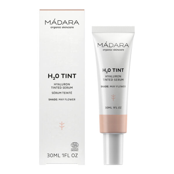 Madara H2O Tinted Hyaluron Serum; tuubi ja rasia MÁDARA H₂O Tint Hyaluron Tinted Serum -tuotetta hyaluronihapolla, sävy May Flower, 30 ml; pakkaus valkoinen mustalla groteskitekstillä, sisältää vaaleanpunaisen tehostealueen; tuubissa mattapinta ja rasiassa suorat reunat; kuva hyvin valaistu, tausta tasainen, ei ihmisiä tai käsiä.