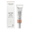 Madara H2O Tinted Hyaluron Serum; tuubi ja rasia Mádara Organic Skincare H₂O Tint Hyaluron Tinted Serum -tuotetta kosteuttavalla hyaluronihapolla, sävy Moon Flower, 30 ml, pystyasennossa valkoisella taustalla; tuubi lieriömäinen mattapinnalla neutraalissa värissä; ulompi rasia mattapintainen samansävyisenä; molemmissa niukkaa groteskitekstiä; brändinimi ja tuotetiedot selkeästi mustalla kirjasimella; ei ihmisiä tai käsiä, kuva tasaisesti valaistu ilman varjoja.