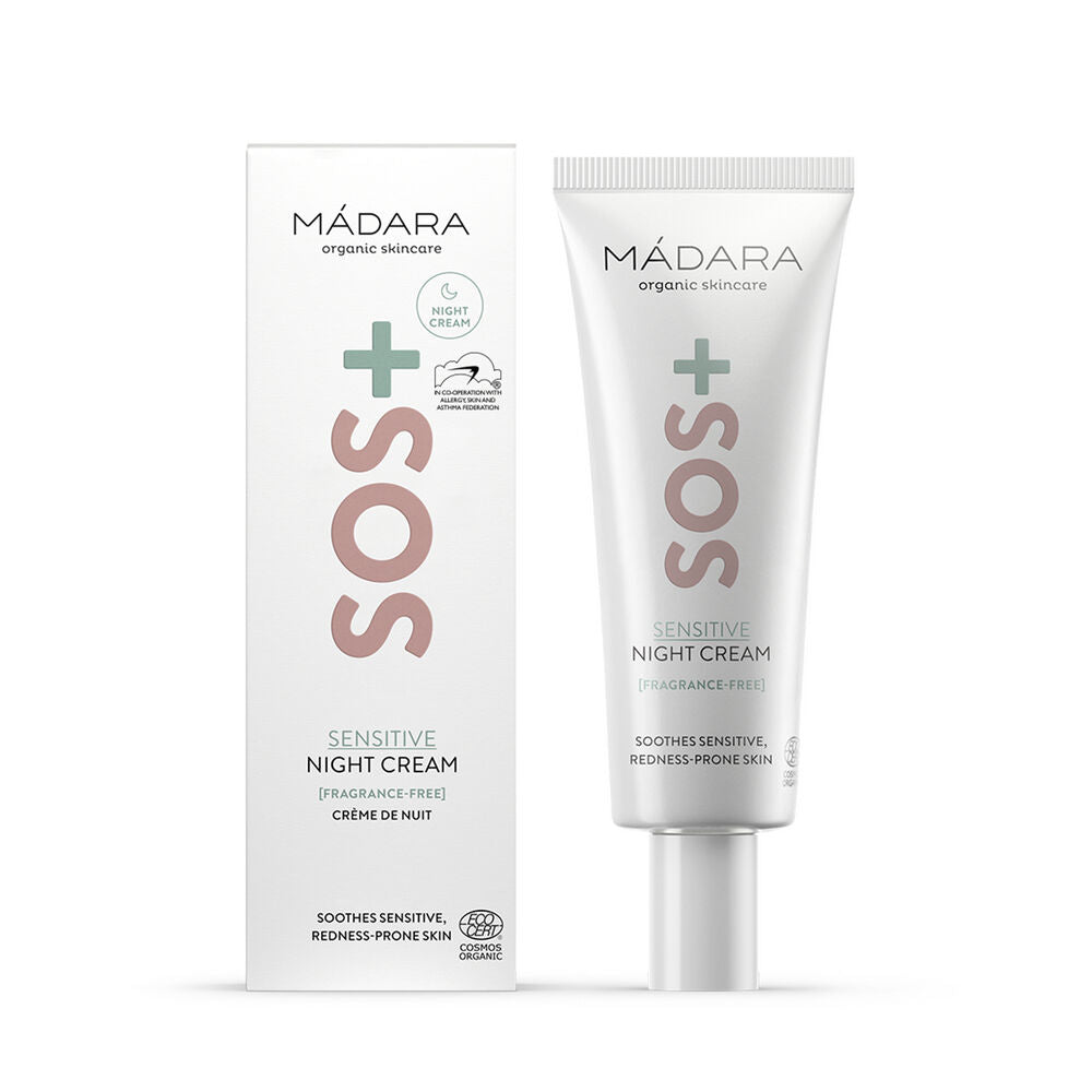 Madara SOS+ SENSITIVE Night Cream; tuubi ja laatikko MÁDARA SOS Sensitive Night Cream -tuotetta, merkitty hajusteettomaksi ja suunniteltu rauhoittamaan herkkää, punoittumisalttiita ihoa; molemmissa pelkistetty vihreä ja pinkki muotoilu; tuubi on mattapintainen suorin sivuin ja litteällä korkilla; laatikko on suorakulmainen samoissa väreissä; siisti groteskityyppi etikettitekstissä; tuote kuvattu yksivärista taustaa vasten, ei ihmisiä tai esineitä näkyvissä.