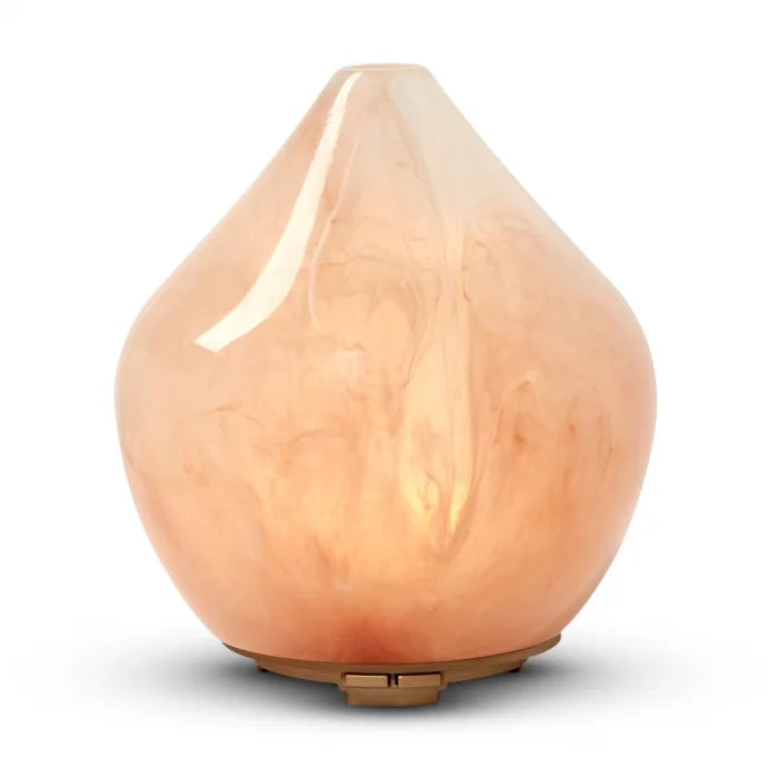 Made by Zen Gem Diffuuseri; persikanvärinen lasinen eteerisen öljyn diffuusori pisaranmuotoisena ja pyöristettynä, pinta kiiltävä ja marmoroitu, pieni puinen jalusta; ei näkyviä etikettejä tai tekstiä; tuote kuvattu yksin yksivärisellä taustalla ilman ihmisiä tai käsiä.