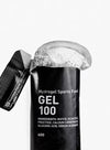 Maurten Gel 100 (12-pack), musta urheilugeelipussi merkitty "Hydrogel Sports Fuel GEL 100", geeliä valumassa ulos; pakkaus mustaa mattapintaista, joustava suorakulmainen muoto; ainesosat ja ravintosisältötiedot painettu selkeästi pienellä fontilla takaosaan; pääetiketti käyttää groteskityppografiaa; tausta valkoinen, lähikuva tuotteesta, ei ihmisiä eikä käsiä näkyvissä.