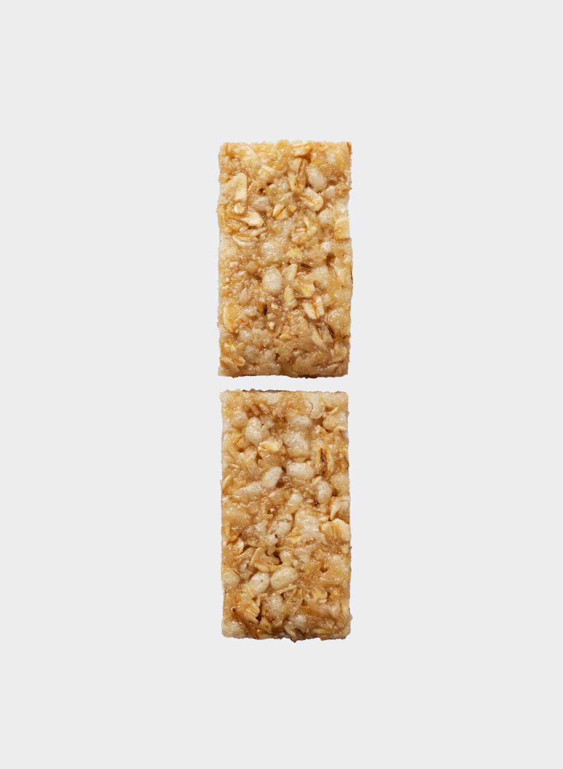 Maurten Solid 160 (40-pack); kaksi suorakulmaista kaura-pähkinämyslipatukkaa aseteltuna pystysuoraan yksinkertaiselle valkoiselle taustalle, pienellä välillä, korostaen kauran ja pähkinöiden terveellistä yhdistelmää; patukoissa karkea, mattapintainen tekstuuri ja näkyviä kaura- ja pähkinäpaloja pinnalla; ei pakkausta, etikettejä, typografiaa, ihmisiä eikä muuta rekvisiittaa kuvassa.