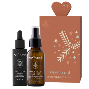 Moi Forest Forest Hydration Duo; kaksi MoiForest-ihonhoitotuotetta — Forest Glow Serum ja Forest Rain Face Mist — esillä mattapintaisen ruskean suorakaiteen muotoisen lahjarasian vieressä valkoisin lehti- ja tähtikuvioin; seerumi pienessä kirkkaassa lasipullossa tippakannella, sumute korkeammassa suihkepullossa; molemmissa minimalistiset etiketit groteskitekstillä; tausta neutraali; ei ihmisiä tai käsiä.