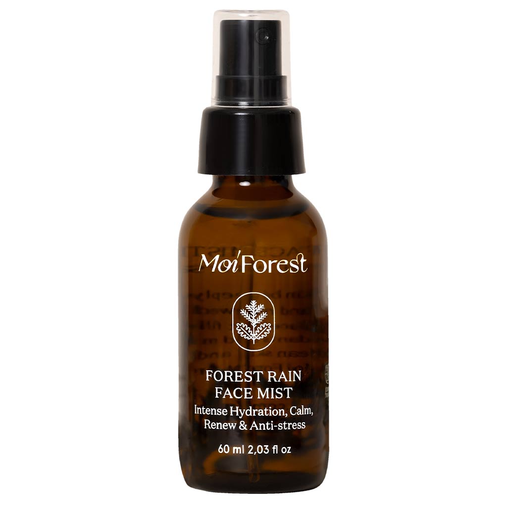 Moi Forest Rain Face Mist; ruskea muovinen suihkepullo mattapinnalla, lieriön muotoinen ja musta pumppusuihkutin; etiketissä teksti "Moi Forest Forest Rain Face Mist" sekä kosteutuksesta, rauhoittavuudesta, uudistumisesta ja stressiä vähentävistä hyödyistä kertova teksti, sisältö 60 ml; typografia siistiä ja sans-serifiä; ei ihmisiä tai muita esineitä kuvassa, kuvattu neutraalia taustaa vasten.