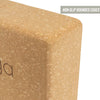Close-up of a sustainable cork yoga block with smooth, rounded edges. Light brown cork material with matte finish. The shape is rectangular with visible curved corners. A small label in the corner shows uppercase text: NON-SLIP ROUNDED EDGES. Cork surface texture and partial printed black text are present on the block. No packaging, people or hands visible; plain background.