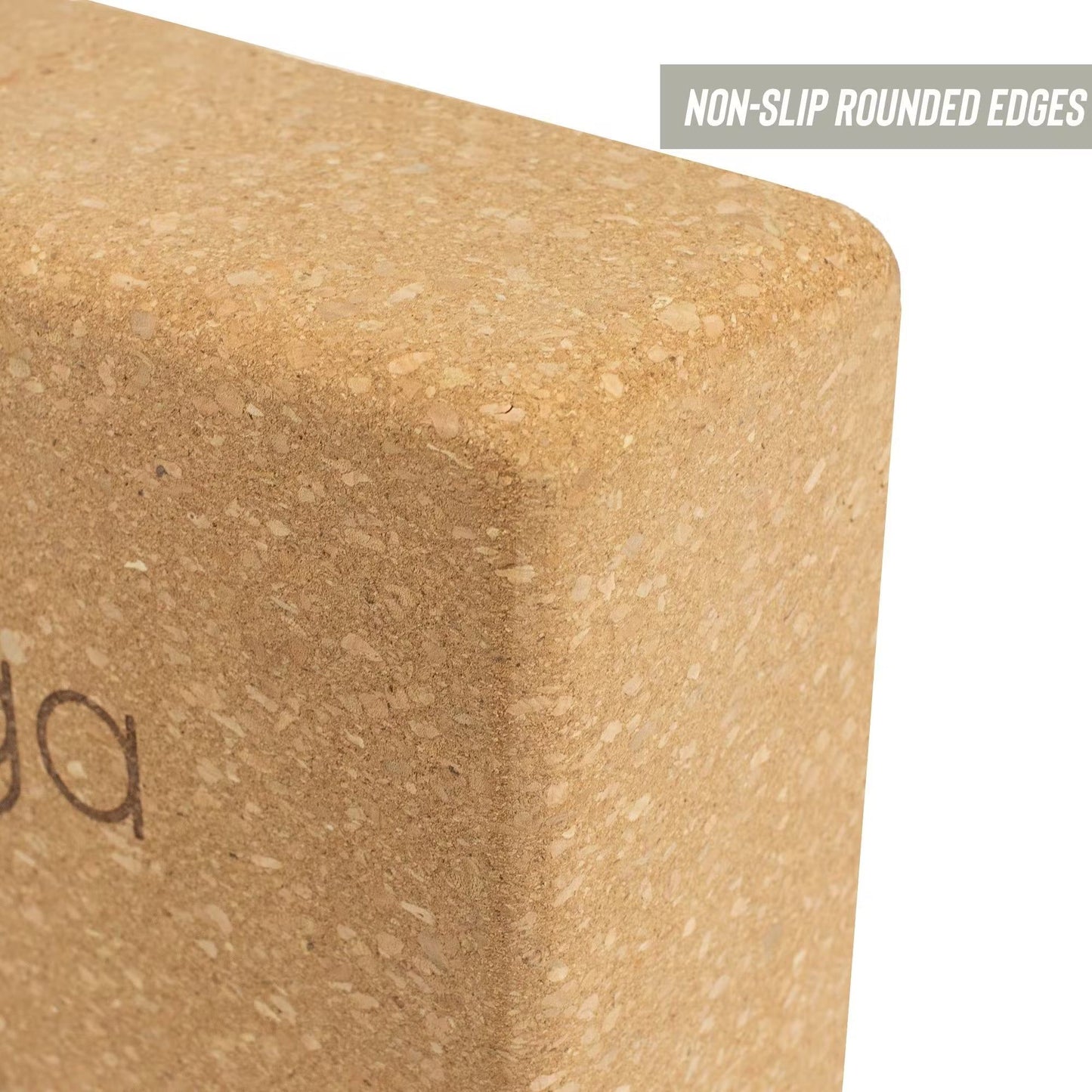 Close-up of a sustainable cork yoga block with smooth, rounded edges. Light brown cork material with matte finish. The shape is rectangular with visible curved corners. A small label in the corner shows uppercase text: NON-SLIP ROUNDED EDGES. Cork surface texture and partial printed black text are present on the block. No packaging, people or hands visible; plain background.