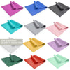 Twelve rolled yoga mats in various vibrant colors, including pink, gray, blue, mint, yellow, red, and green, arranged in a grid. Mats are cylindrical with a matte finish. No packaging visible. The background is white. Bold sans-serif label on the image reads: OVER 10 DIFFERENT COLOURS TO CHOOSE FROM. No people or hands present.