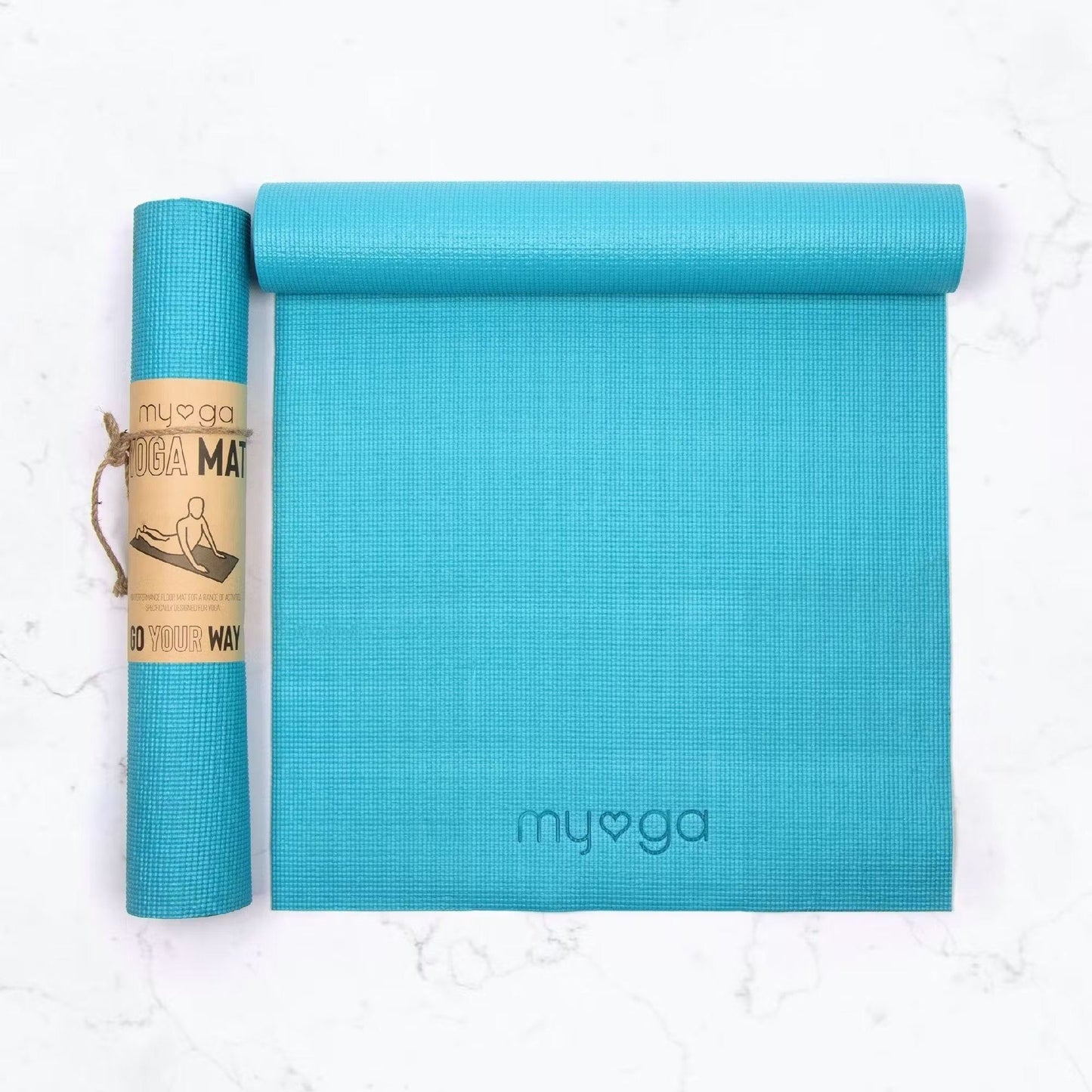 A rolled and an unrolled turquoise yoga mat on a white surface. Both mats are rectangular with a matte finish. The unrolled mat displays the word “myoga” in lowercase, minimalist sans-serif lettering. The rolled mat is secured in a brown paper band with dark, decorative line art. No people or hands are visible. Overhead product shot.